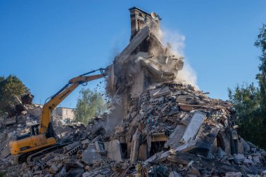 Gostomel, Kyiv Ukrayna - 25 Eylül. 2022: Bir kazıcı kovayla bir evi yok etti. Ev, Rus birlikleri tarafından işgal sırasında hasar gördü ve bir bomba tarafından vuruldu.. .