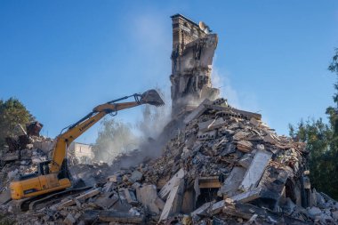 Gostomel, Kyiv Ukrayna - 25 Eylül. 2022: Bir kazıcı kovayla bir evi yok etti. Ev, Rus birlikleri tarafından işgal sırasında hasar gördü ve bir bomba tarafından vuruldu.. .