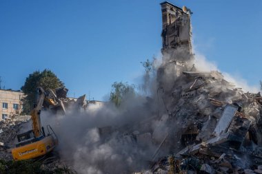 Gostomel, Kyiv Ukrayna - 25 Eylül. 2022: Bir kazıcı kovayla bir evi yok etti. Ev, Rus birlikleri tarafından işgal sırasında hasar gördü ve bir bomba tarafından vuruldu.. .