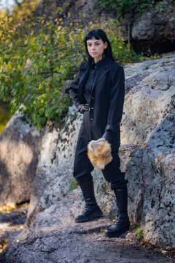 Bir sonbahar günü, tilki şapkalı ve siyah takım elbiseli bir kız nehrin granit kıyısında..