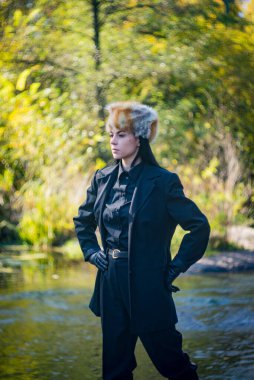 Bir sonbahar günü, tilki şapkalı ve siyah takım elbiseli bir kız nehrin granit kıyısında..