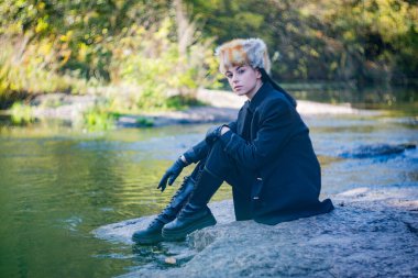 Bir sonbahar günü, tilki şapkalı ve siyah takım elbiseli bir kız nehrin granit kıyısında..