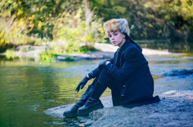 Bir sonbahar günü, tilki şapkalı ve siyah takım elbiseli bir kız nehrin granit kıyısında..