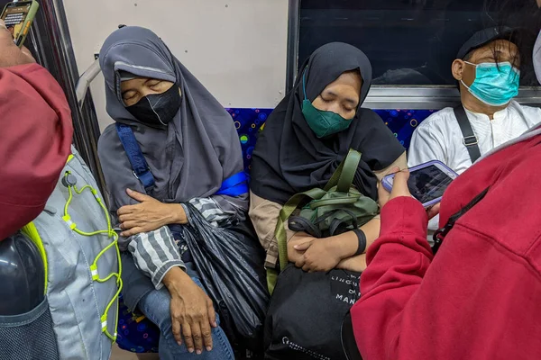 İşten eve giden iki kadın ya banliyö hattında ya da tren yolcuları arasında uyuyorlar. Jakarta, Endonezya - 27 Mayıs 2022.