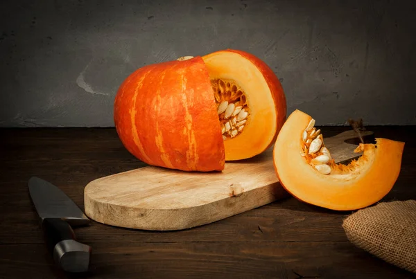 Eine Scheibe Orangenkürbis Mit Kernen Liegt Auf Einem Holzbrett — Stockfoto