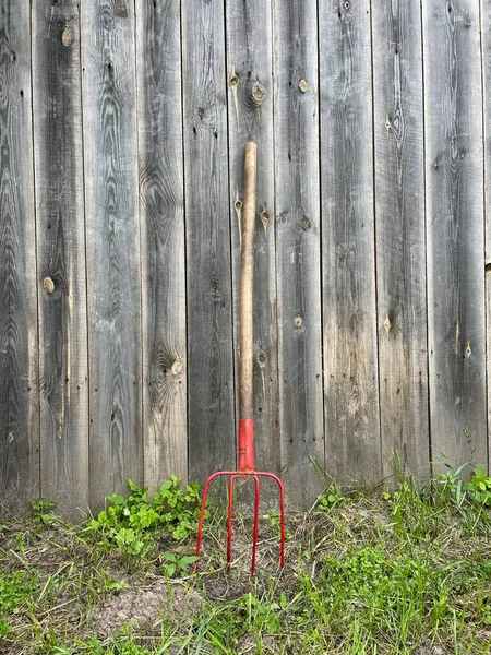 Rote Gartenmistgabel Gegen Holzzaun — Stockfoto