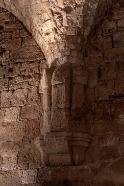 İsrail 'in kuzeyindeki eski Acre kentinin Haçlı Kalesi' ndeki yeniden inşa edilmiş büyük taş yemek odasında dekoratif taş oymalarla süslenmiş sütun tabanı.