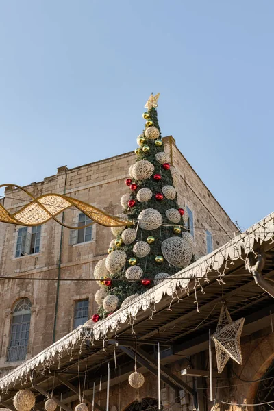 Jerusalem, Israel, December 25, 2021 : A festively decorated Christmas tree for the celebration of Christmas, in the early morning stands on the roof near the New Gate in the Old City of Jerusalem, in Israel