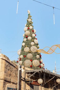 Jerusalem, Israel, December 25, 2021 : A festively decorated Christmas tree for the celebration of Christmas, in the early morning stands on the roof near the New Gate in the Old City of Jerusalem, in Israel