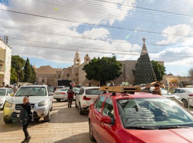Bethlehem, Israel, December 25, 2021 : A Christmas tree decorated in celebration of Christmas on the crowded central Manager Square Street in Bethlehem in the Palestinian Authority, Israel