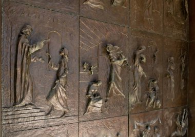 Nasıra, İsrail, 12 Şubat 2022: İsrail 'in kuzeyindeki Nasıra' daki Annunciation Kilisesi 'nin yan girişinin metal kapısında İncil' den hikayeler tasvir eden tasvir ediciler