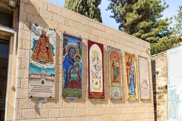 Nazareth, Israel, February 12, 2022 : Icons donated to the church from different countries depicting the Virgin Mary and the baby in her arms hang on the walls in the courtyard of the Church Of Annunciation in Nazareth, northern Israel