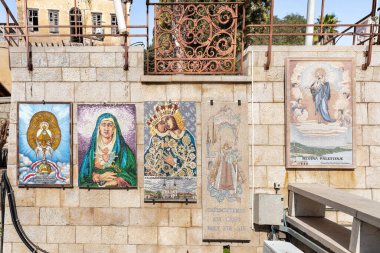 Nasıra, İsrail, 12 Şubat 2022: Bakire Meryem 'in ve kollarındaki bebeğin resmedildiği farklı ülkelerden kiliselere bağışlanan ikonlar, İsrail' in kuzeyindeki Nasıra 'daki Annunciation Kilisesi' nin avlusunda asılı duruyor.