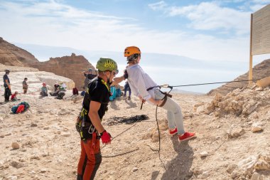 Kudüs, İsrail, 16 Nisan 2022: Tecrübeli bir eğitmen, İsrail 'in Kudüs yakınlarındaki Tamarim deresi yakınlarındaki Musevi Çölü' nün dağlarında bu ekipmanların nasıl kullanılacağını yeni başlayanlara açıklıyor.