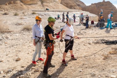 Kudüs, İsrail, 16 Nisan 2022: Tecrübeli bir eğitmen, İsrail 'in Kudüs yakınlarındaki Tamarim deresi yakınlarındaki Musevi Çölü' nün dağlarında bu ekipmanların nasıl kullanılacağını yeni başlayanlara açıklıyor.