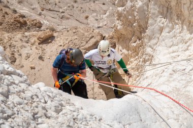 Kudüs, İsrail, 16 Nisan 2022: Genç sporcular, İsrail 'in Kudüs yakınlarındaki Tamarim deresi yakınlarındaki Judean Çölü' nün dağlarında kırma teçhizatı kullanarak iniş yapmaya başladılar