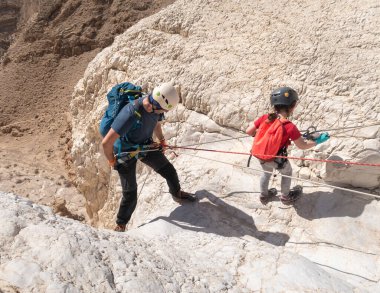 Kudüs, İsrail, 16 Nisan 2022: Sporcular, İsrail 'in Kudüs yakınlarındaki Tamarim deresi yakınlarındaki Musevi Çölü' nün dağlarında çatırdamak için ekipmanla dağdan inmeye başladılar.