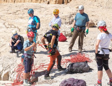 Kudüs, İsrail, 16 Nisan 2022: Deneyimli sporcular, İsrail 'in Kudüs yakınlarındaki Tamarim deresi yakınlarındaki Musevi Çölü' nün dağlarındaki dağlara inmeden önce yakalama ekipmanlarını kontrol ediyorlar.