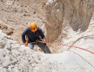 Kudüs, İsrail, 16 Nisan 2022: Tecrübeli bir atlet İsrail 'in Kudüs yakınlarındaki Tamarim deresi yakınlarındaki Musevi Çölü' nün dağlarında kopan aletlerle inişe geçiyor.
