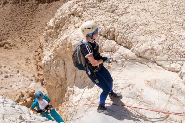 Kudüs, İsrail, 16 Nisan 2022: Deneyimli sporcular, İsrail 'in Kudüs yakınlarındaki Tamarim deresi yakınlarındaki Musevi Çölü' nün dağlarında kopan aletlerle inişe geçtiler.