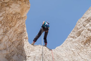Kudüs, İsrail, 16 Nisan 2022: Deneyimli bir atlet, İsrail 'in Kudüs yakınlarındaki Tamarim deresi yakınlarındaki Musevi Çölü' nün dağlarında kırılma ekipmanlarıyla birlikte iniyor.