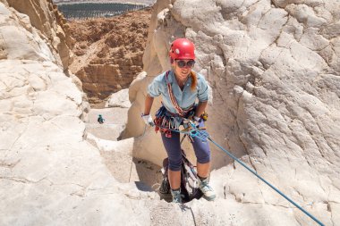 Kudüs, İsrail, 16 Nisan 2022: Deneyimli bir atlet, İsrail 'in Kudüs yakınlarındaki Tamarim deresi yakınlarındaki Musevi Çölü' nün dağlarında kırılma ekipmanlarıyla birlikte iniyor.