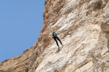 Kudüs, İsrail, 16 Nisan 2022: Deneyimli bir atlet, İsrail 'in Kudüs yakınlarındaki Tamarim deresi yakınlarındaki Musevi Çölü' nün dağlarında kırılma ekipmanlarıyla birlikte iniyor.