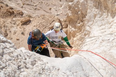 Kudüs, İsrail, 16 Nisan 2022: Genç sporcular, İsrail 'in Kudüs yakınlarındaki Tamarim deresi yakınlarındaki Judean Çölü' nün dağlarında kırma teçhizatı kullanarak iniş yapmaya başladılar