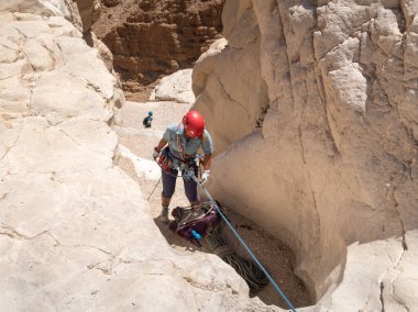 Kudüs, İsrail, 16 Nisan 2022: Deneyimli bir atlet, İsrail 'in Kudüs yakınlarındaki Tamarim deresi yakınlarındaki Musevi Çölü' nün dağlarında kırılma ekipmanlarıyla birlikte iniyor.