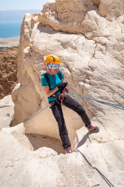 Kudüs, İsrail, 16 Nisan 2022: Deneyimli bir atlet, İsrail 'in Kudüs yakınlarındaki Tamarim deresi yakınlarındaki Musevi Çölü' nün dağlarında kırılma ekipmanlarıyla birlikte iniyor.