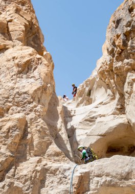 Kudüs, İsrail, 16 Nisan 2022: Deneyimli bir atlet, İsrail 'in Kudüs yakınlarındaki Tamarim deresi yakınlarındaki Musevi Çölü' nün dağlarında kırılma ekipmanlarıyla birlikte iniyor.
