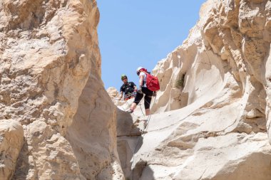 Kudüs, İsrail, 16 Nisan 2022: Deneyimli bir atlet, İsrail 'in Kudüs yakınlarındaki Tamarim deresi yakınlarındaki Musevi Çölü' nün dağlarında kırılma ekipmanlarıyla birlikte iniyor.