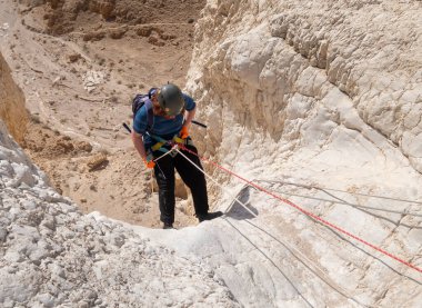 Kudüs, İsrail, 16 Nisan 2022: Genç bir atlet, İsrail 'in Kudüs yakınlarındaki Tamarim deresi yakınlarındaki Judean Çölü' nün dağlarında kırma teçhizatı kullanarak yokuş aşağı inmeye başladı