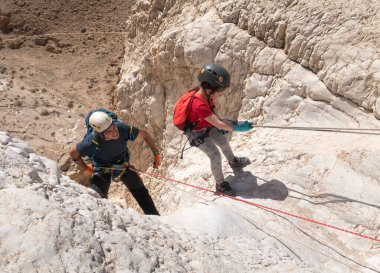 Kudüs, İsrail, 16 Nisan 2022: Sporcular, İsrail 'in Kudüs yakınlarındaki Tamarim deresi yakınlarındaki Musevi Çölü' nün dağlarında çatırdamak için ekipmanla dağdan inmeye başladılar.
