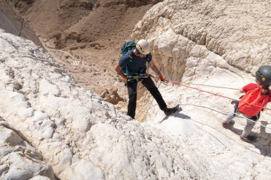 Kudüs, İsrail, 16 Nisan 2022: Sporcular, İsrail 'in Kudüs yakınlarındaki Tamarim deresi yakınlarındaki Musevi Çölü' nün dağlarında çatırdamak için ekipmanla dağdan inmeye başladılar.