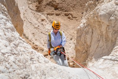 Kudüs, İsrail, 16 Nisan 2022: Tecrübeli bir atlet İsrail 'in Kudüs yakınlarındaki Tamarim deresi yakınlarındaki Musevi Çölü' nün dağlarında kopan aletlerle inişe geçiyor.