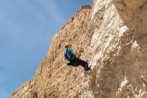 Kudüs, İsrail, 16 Nisan 2022: Deneyimli bir atlet, İsrail 'in Kudüs yakınlarındaki Tamarim deresi yakınlarındaki Musevi Çölü' nün dağlarında kırılma ekipmanlarıyla birlikte iniyor.
