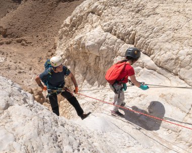 Kudüs, İsrail, 16 Nisan 2022: Sporcular, İsrail 'in Kudüs yakınlarındaki Tamarim deresi yakınlarındaki Musevi Çölü' nün dağlarında çatırdamak için ekipmanla dağdan inmeye başladılar.
