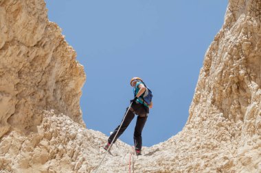 Kudüs, İsrail, 16 Nisan 2022: Deneyimli bir atlet, İsrail 'in Kudüs yakınlarındaki Tamarim deresi yakınlarındaki Musevi Çölü' nün dağlarında kırılma ekipmanlarıyla birlikte iniyor.