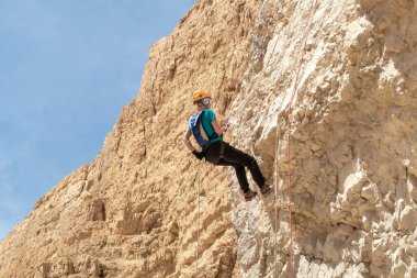 Kudüs, İsrail, 16 Nisan 2022: Deneyimli bir atlet, İsrail 'in Kudüs yakınlarındaki Tamarim deresi yakınlarındaki Musevi Çölü' nün dağlarında kırılma ekipmanlarıyla birlikte iniyor.