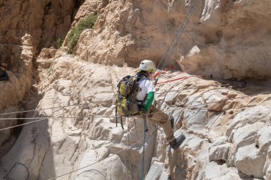Kudüs, İsrail, 16 Nisan 2022: Deneyimli bir atlet, İsrail 'in Kudüs yakınlarındaki Tamarim deresi yakınlarındaki Musevi Çölü' nün dağlarında kırılma ekipmanlarıyla birlikte iniyor.