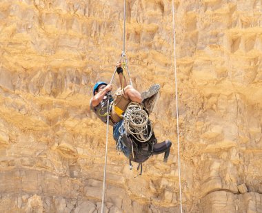 Kudüs, İsrail, 16 Nisan 2022: Deneyimli bir atlet, İsrail 'in Kudüs yakınlarındaki Tamarim deresi yakınlarındaki Musevi Çölü' nün dağlarında kırılma ekipmanlarıyla birlikte iniyor.