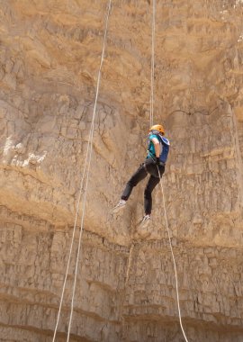 Kudüs, İsrail, 16 Nisan 2022: Deneyimli bir atlet, İsrail 'in Kudüs yakınlarındaki Tamarim deresi yakınlarındaki Musevi Çölü' nün dağlarında kırılma ekipmanlarıyla birlikte iniyor.