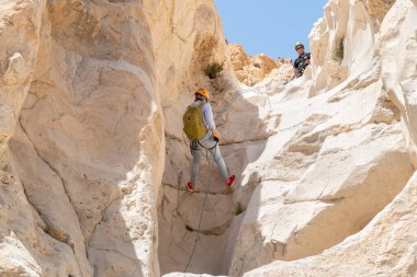 Kudüs, İsrail, 16 Nisan 2022: Deneyimli bir atlet, İsrail 'in Kudüs yakınlarındaki Tamarim deresi yakınlarındaki Musevi Çölü' nün dağlarında kırılma ekipmanlarıyla birlikte iniyor.