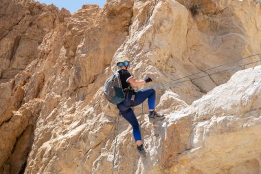 Kudüs, İsrail, 16 Nisan 2022: Deneyimli bir atlet, İsrail 'in Kudüs yakınlarındaki Tamarim deresi yakınlarındaki Musevi Çölü' nün dağlarında kırılma ekipmanlarıyla birlikte iniyor.