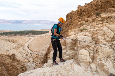 Kudüs, İsrail, 16 Nisan 2022: Tecrübeli bir atlet, İsrail 'in Kudüs yakınlarındaki Tamarim deresi yakınlarındaki Musevi Çölü' nün dağlarında kırılacak aletlerle baş aşağı iniyor.