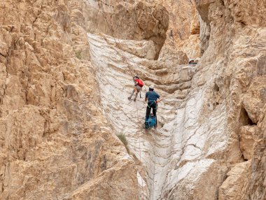 Kudüs, İsrail, 16 Nisan 2022: Deneyimli sporcular, İsrail 'in Kudüs yakınlarındaki Tamarim deresi yakınlarındaki Musevi Çölü' nün dağlarında kopan aletlerle inişe geçtiler.