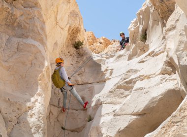 Kudüs, İsrail, 16 Nisan 2022: Deneyimli bir atlet, İsrail 'in Kudüs yakınlarındaki Tamarim deresi yakınlarındaki Musevi Çölü' nün dağlarında kırılma ekipmanlarıyla birlikte iniyor.