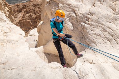 Kudüs, İsrail, 16 Nisan 2022: Deneyimli bir atlet, İsrail 'in Kudüs yakınlarındaki Tamarim deresi yakınlarındaki Musevi Çölü' nün dağlarında kırılma ekipmanlarıyla birlikte iniyor.