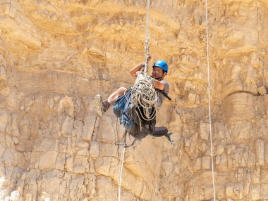 Kudüs, İsrail, 16 Nisan 2022: Deneyimli bir atlet, İsrail 'in Kudüs yakınlarındaki Tamarim deresi yakınlarındaki Musevi Çölü' nün dağlarında kırılma ekipmanlarıyla birlikte iniyor.